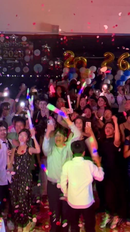 Crowd with glowing LED foam sticks and confetti