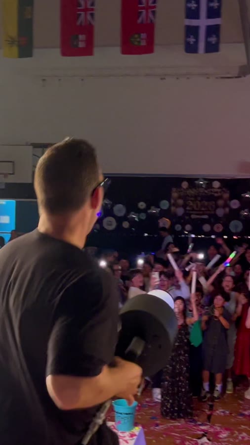 Crowd with hands in the air facing the DJ